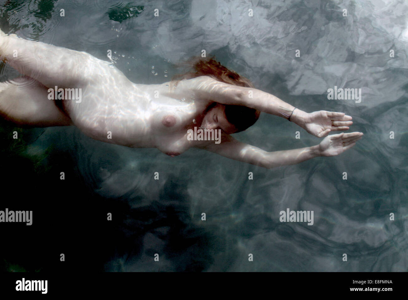 Nudo di donna incinta nuoto sott'acqua Foto Stock