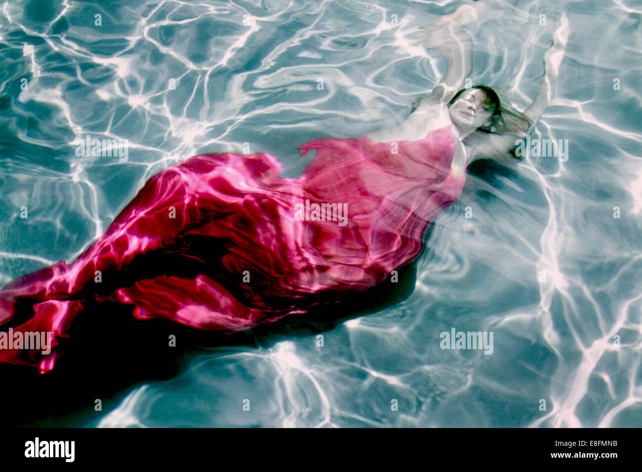 Vista dall'alto di una donna in un abito che nuota sott'acqua Foto Stock