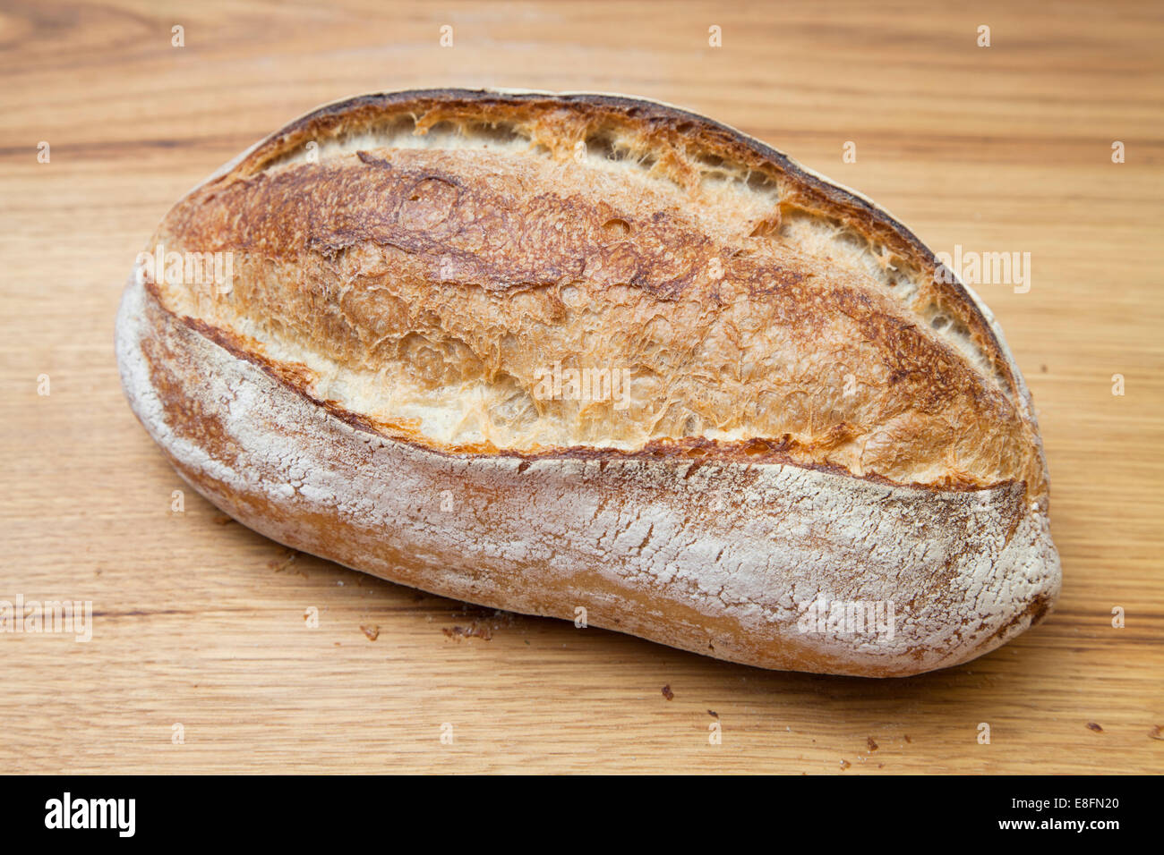 Primo piano di una pagnotta di pane fresco su un tavolo Foto Stock