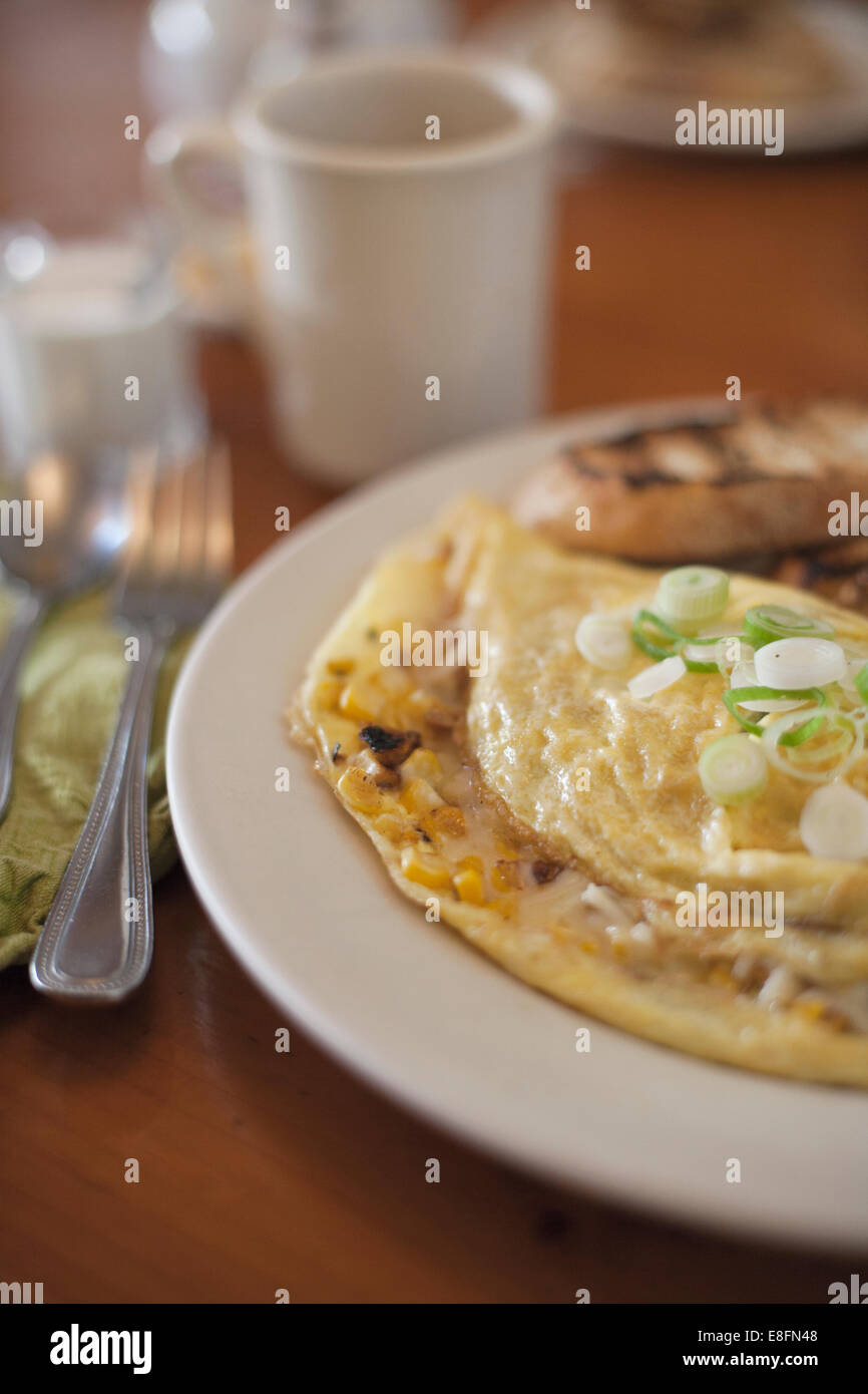 Close-up di formaggio e cipolle Frittata prima colazione con pane tostato Foto Stock