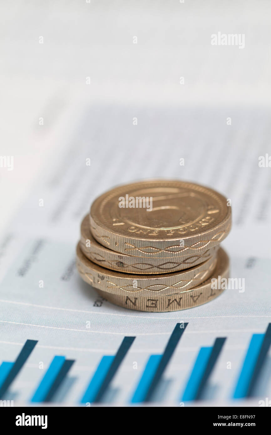 Pila di monete sterlina sui dati finanziari Foto Stock