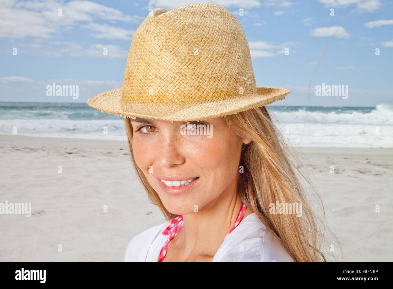 Ritratto di donna sorridente sulla spiaggia nel cappello di paglia, Cape Town, Sud Africa Foto Stock