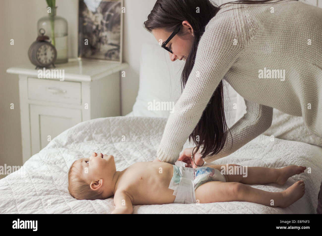 Donna modifica figlio il pannolino Foto Stock