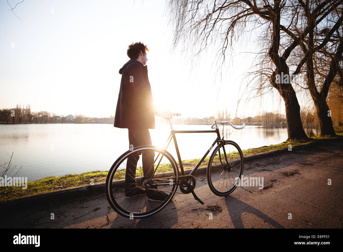 Adolescente (14-15) in piedi con la bicicletta dal fiume Foto Stock