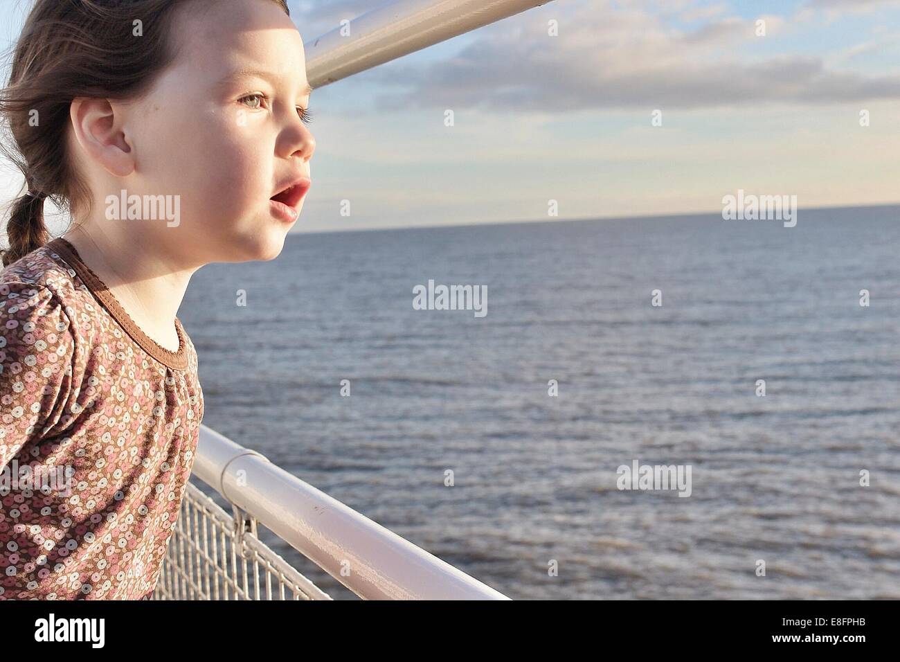 Ragazza in piedi sulla barca che guarda al mare Foto Stock