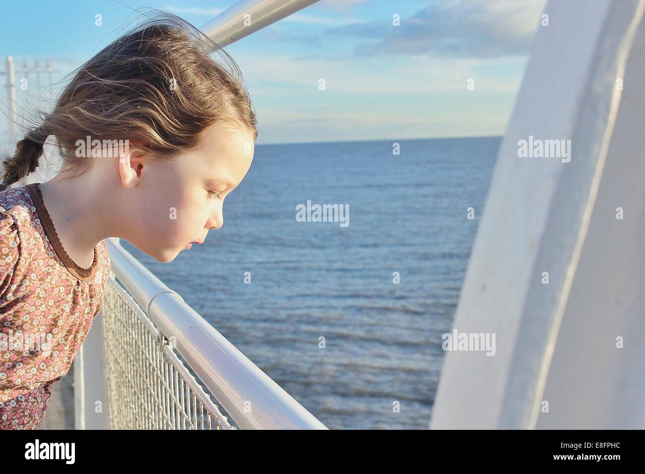 Ragazza in piedi sulla barca che guarda al mare Foto Stock