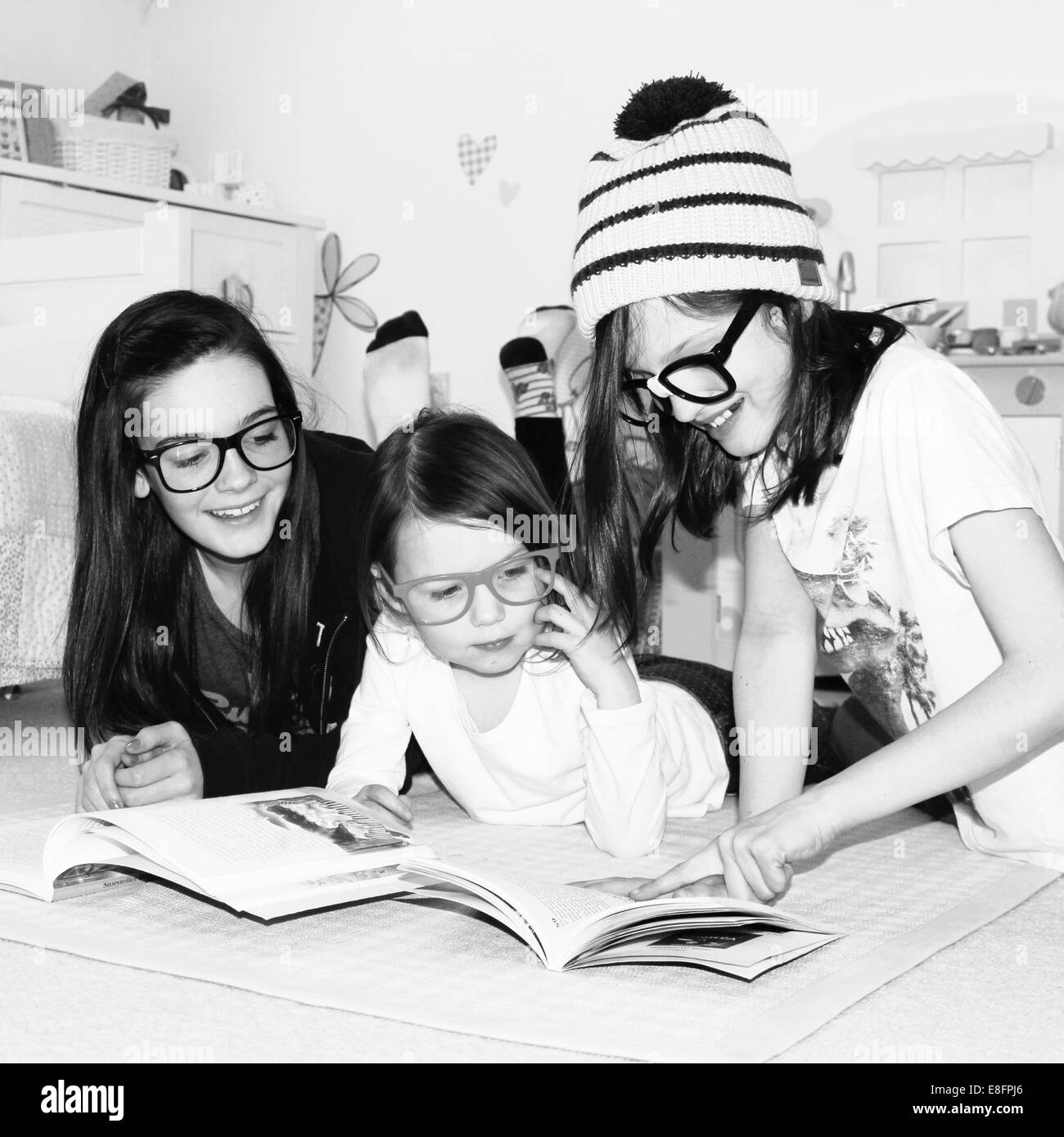 Ritratto di tre ragazze sorridenti la lettura di libri Foto Stock