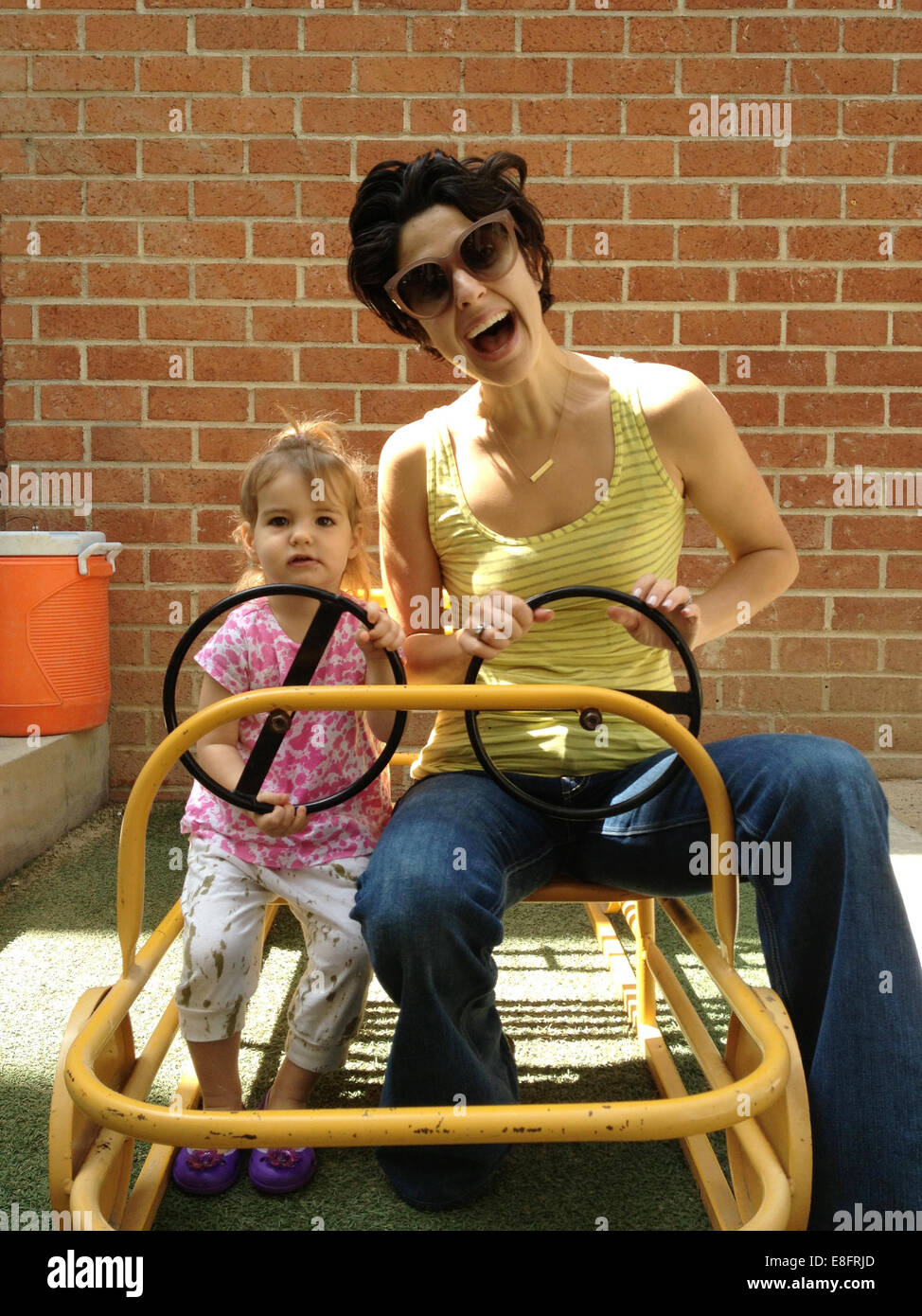 Madre e figlia (18-23 mesi) carrello di guida Foto Stock