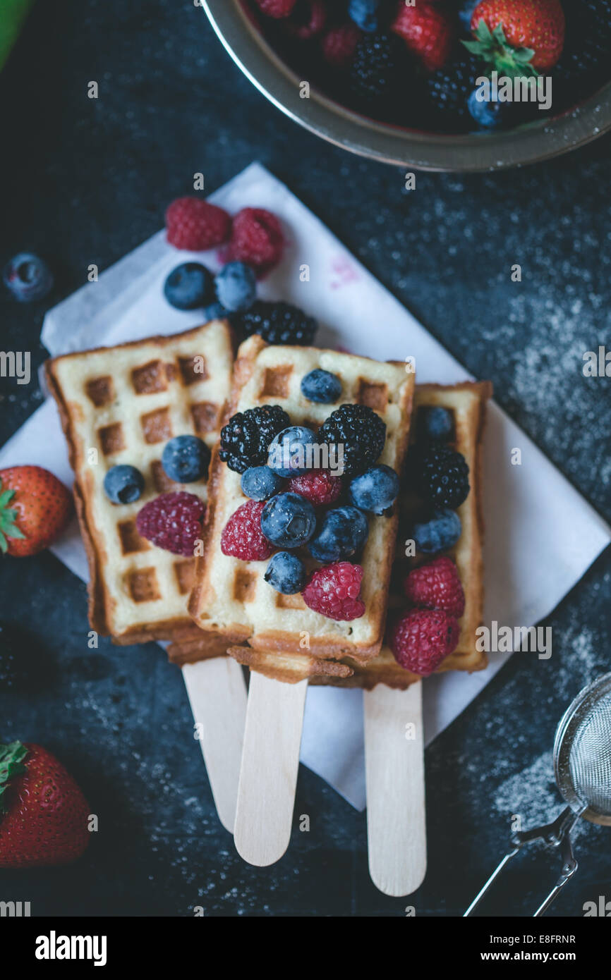 Waffle su bastoncini con fragole, more e mirtilli Foto Stock