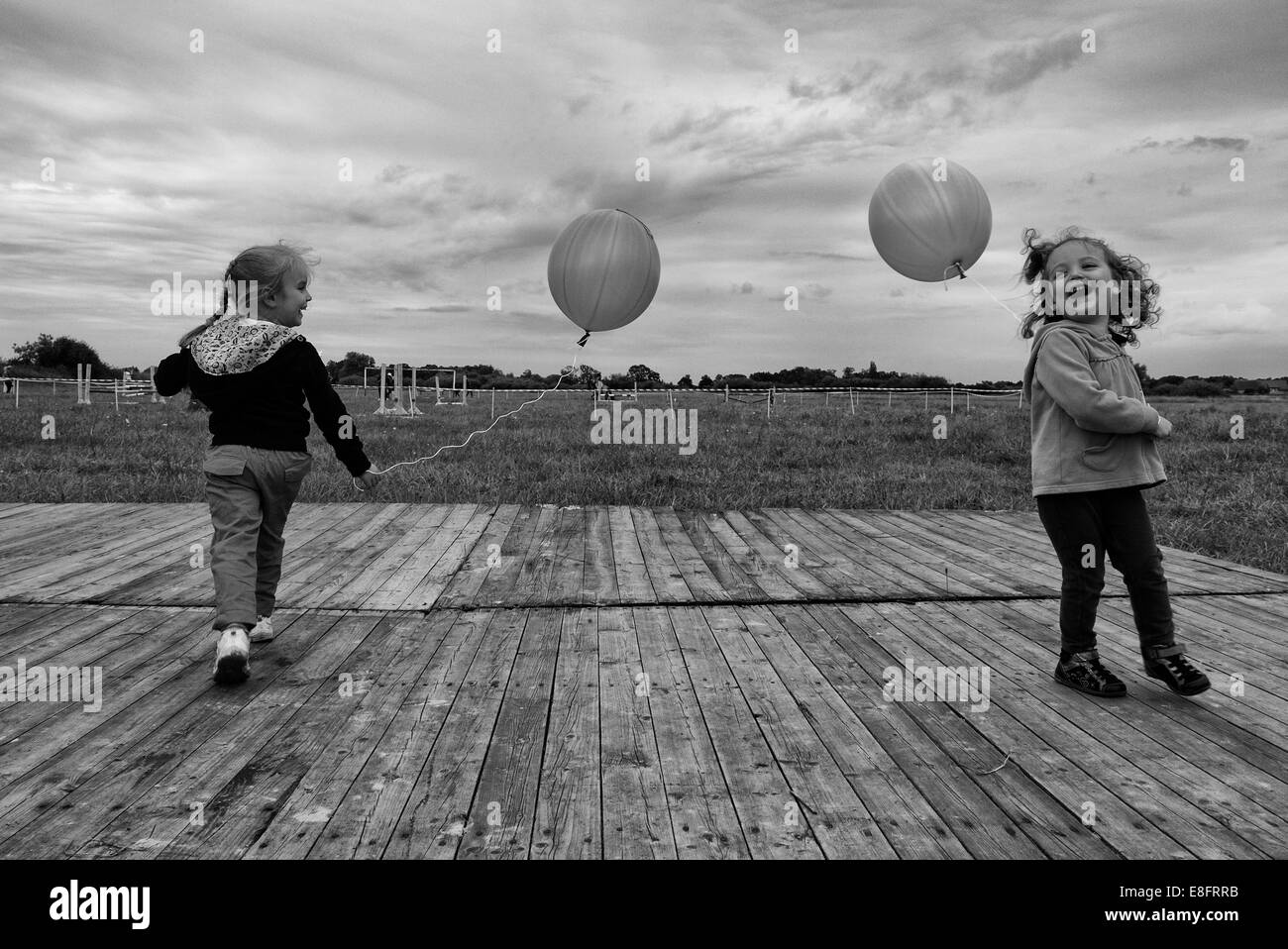 Due ragazze che giocano all'aperto con palloncini Foto Stock