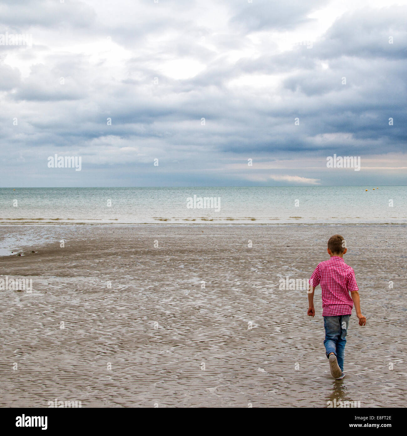 Ragazzo correre sulla spiaggia Foto Stock