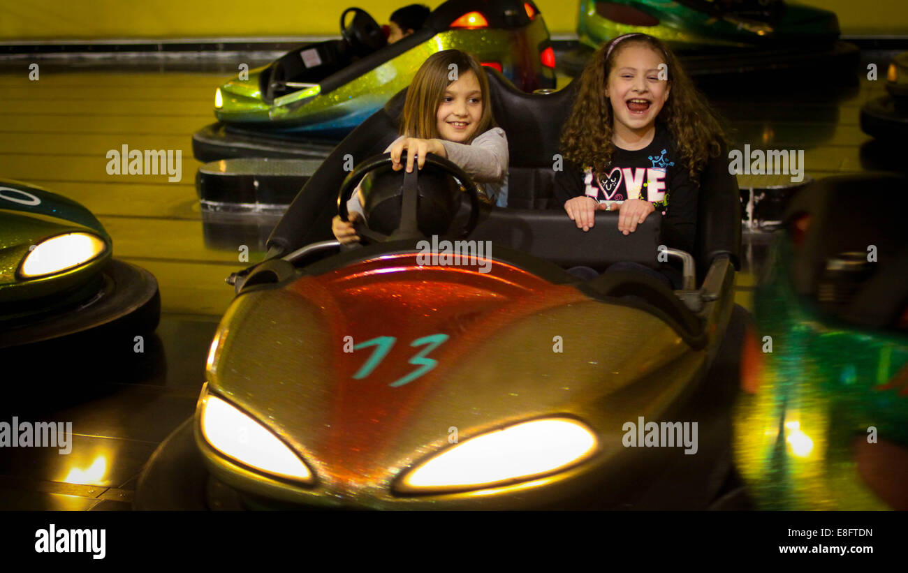 Due ragazze nel paraurti di automobili a una fiera Foto Stock