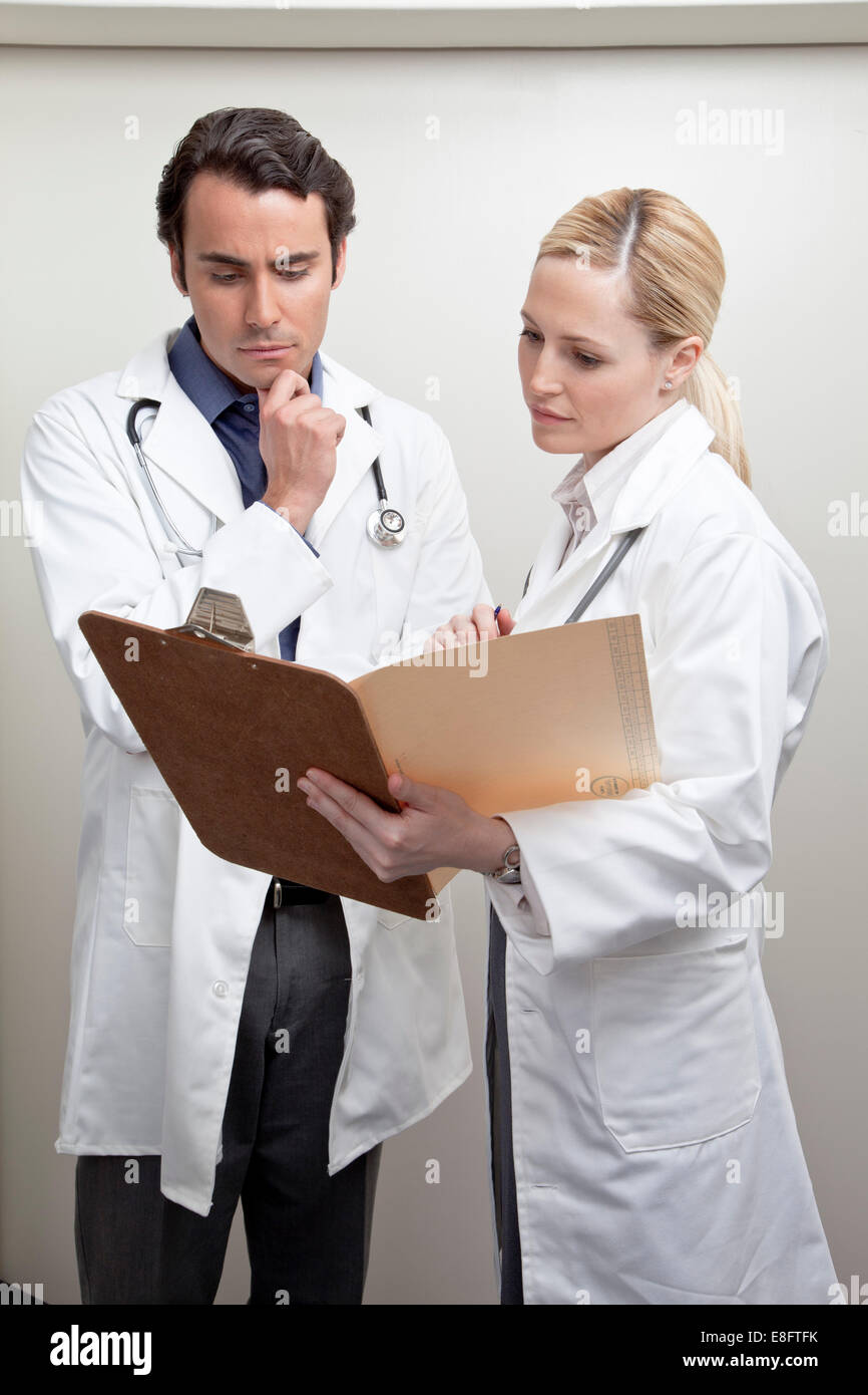 Maschio e femmina medico guardando un grafico di medico Foto Stock
