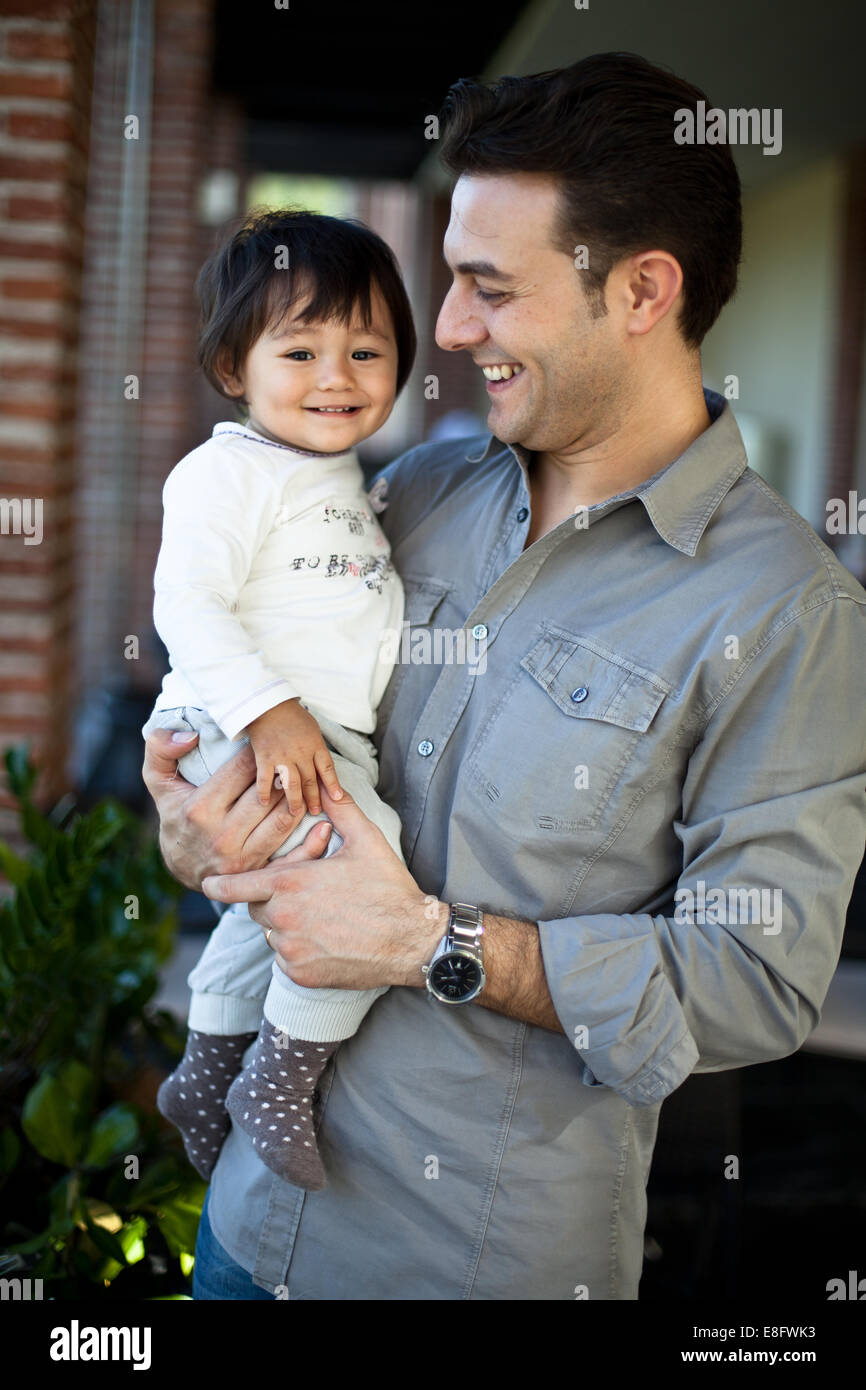 Padre sorridente tenendo la sua figlia Foto Stock
