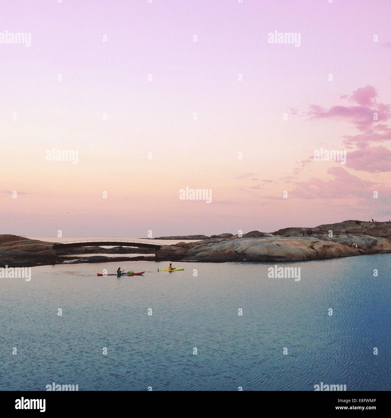 Due persone fare kayak al tramonto, Norvegia Foto Stock