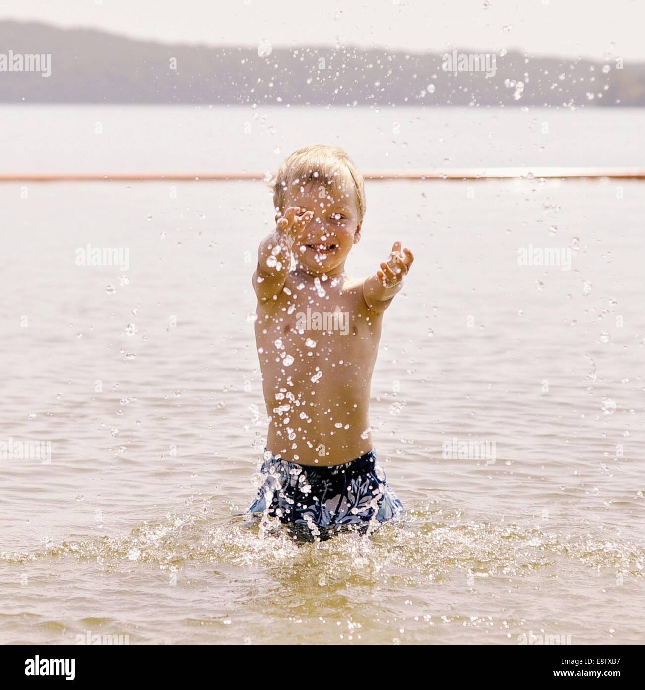 Ragazzo schizzi circa in mare Foto Stock