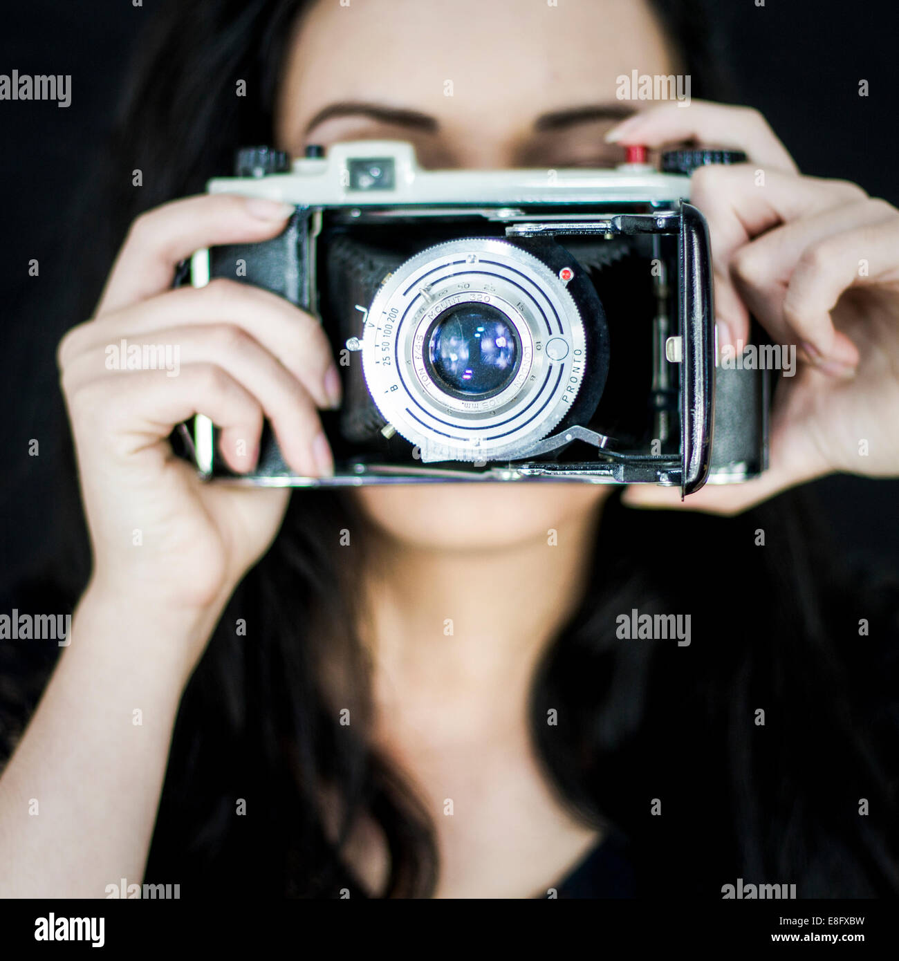 Giovane donna con la vecchia macchina fotografica Foto Stock