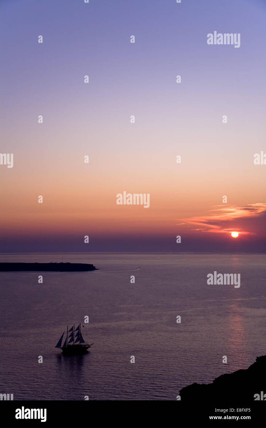 La Grecia, Egeo Meridionale Peripher, Cicladi, Santorini, nave a vela in mare durante il tramonto Foto Stock