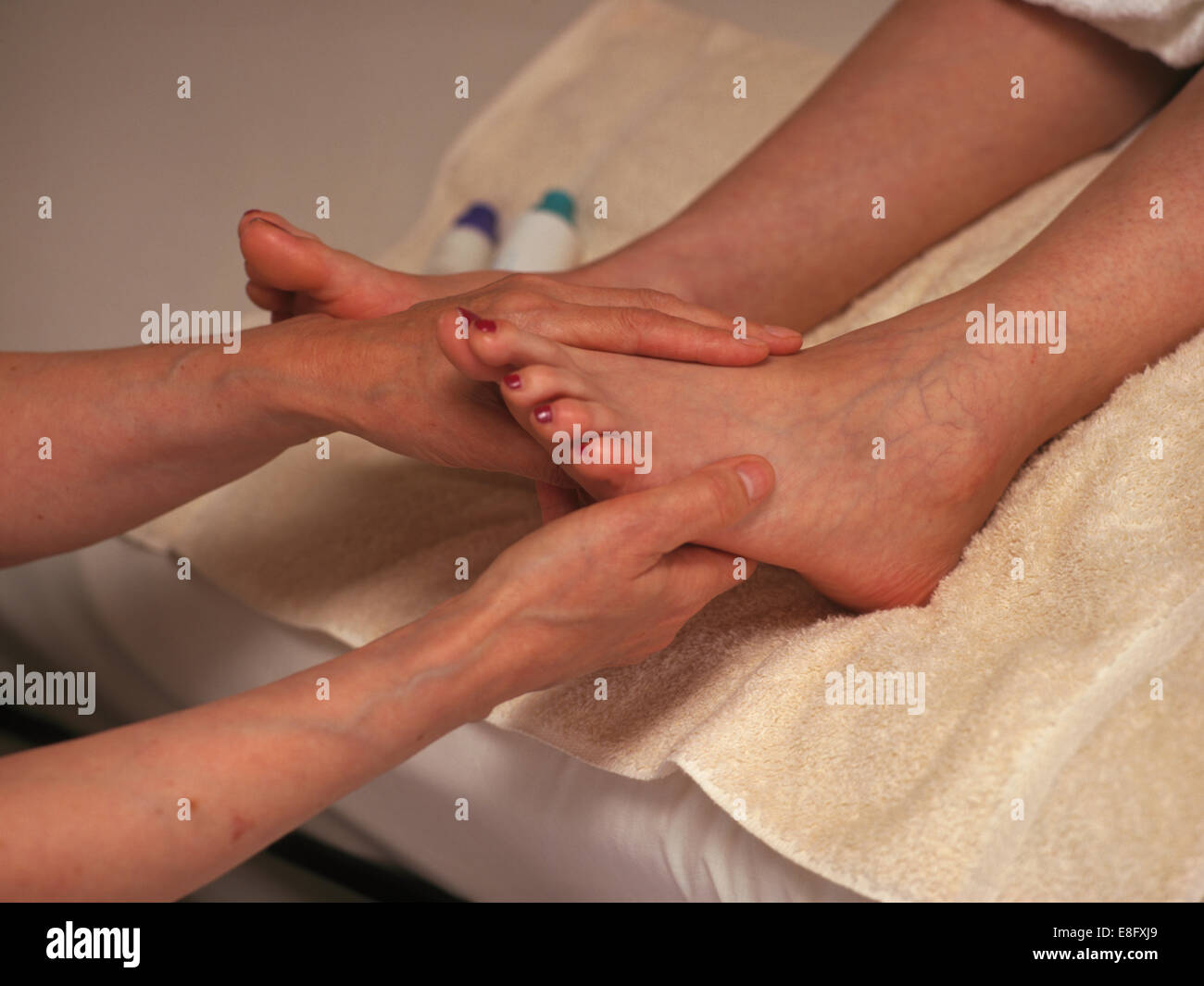 La riflessologia terapista lavorando sui piedi di un client Foto Stock