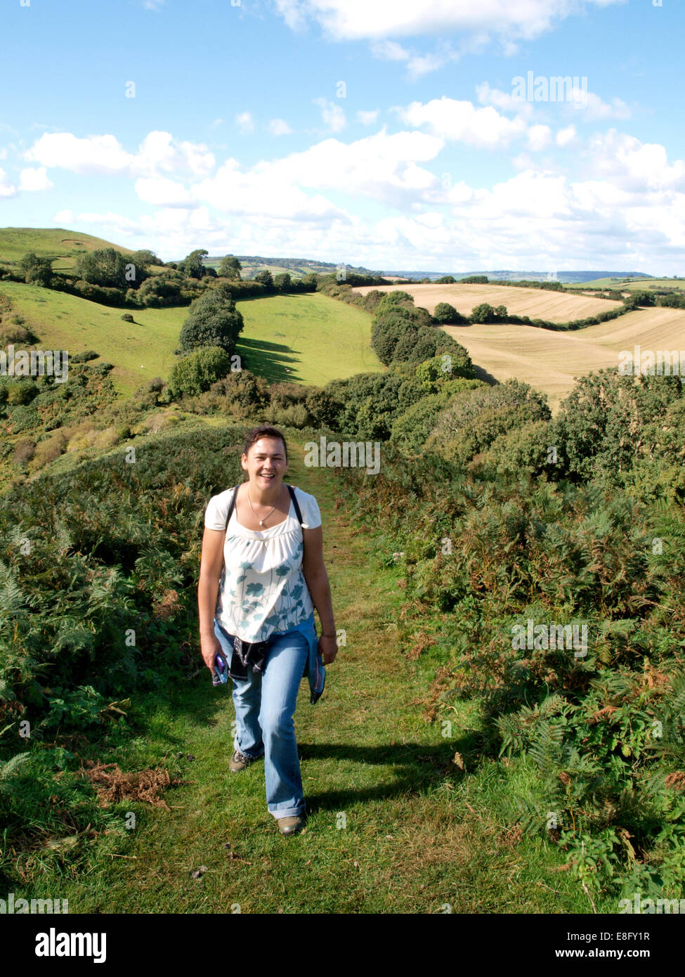 Donna che cammina fino Colmer's Hill, Symondsbury, Dorset, Regno Unito Foto Stock