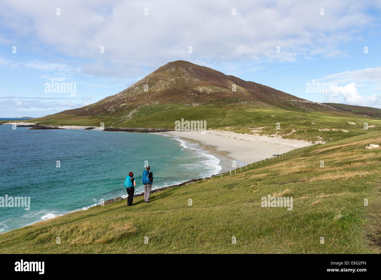 Due escursionisti godendo della vista sulla spiaggia di Traigh na Cleabhaig alla collina di Ceapabhal, Isle of Harris Ebridi Scozia Scotland Foto Stock