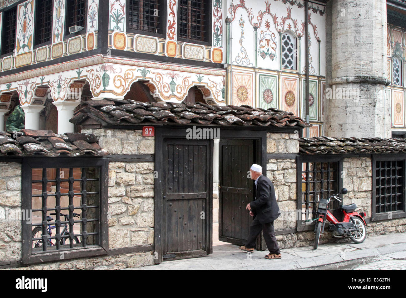 Un uomo cammina attraverso un cancello in motivi di Šarena Džamija, spesso noto come la Moschea dipinta in Tetova, Macedonia Foto Stock