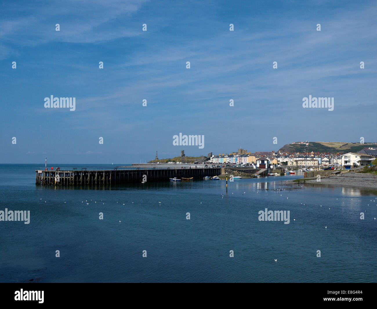 Aberystwyth Harbour, il lungomare con il memoriale di guerra e le rovine del castello di oltre Foto Stock