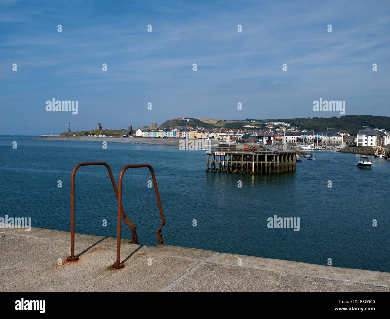 Aberystwyth Harbour, il lungomare con il memoriale di guerra e le rovine del castello di oltre Foto Stock