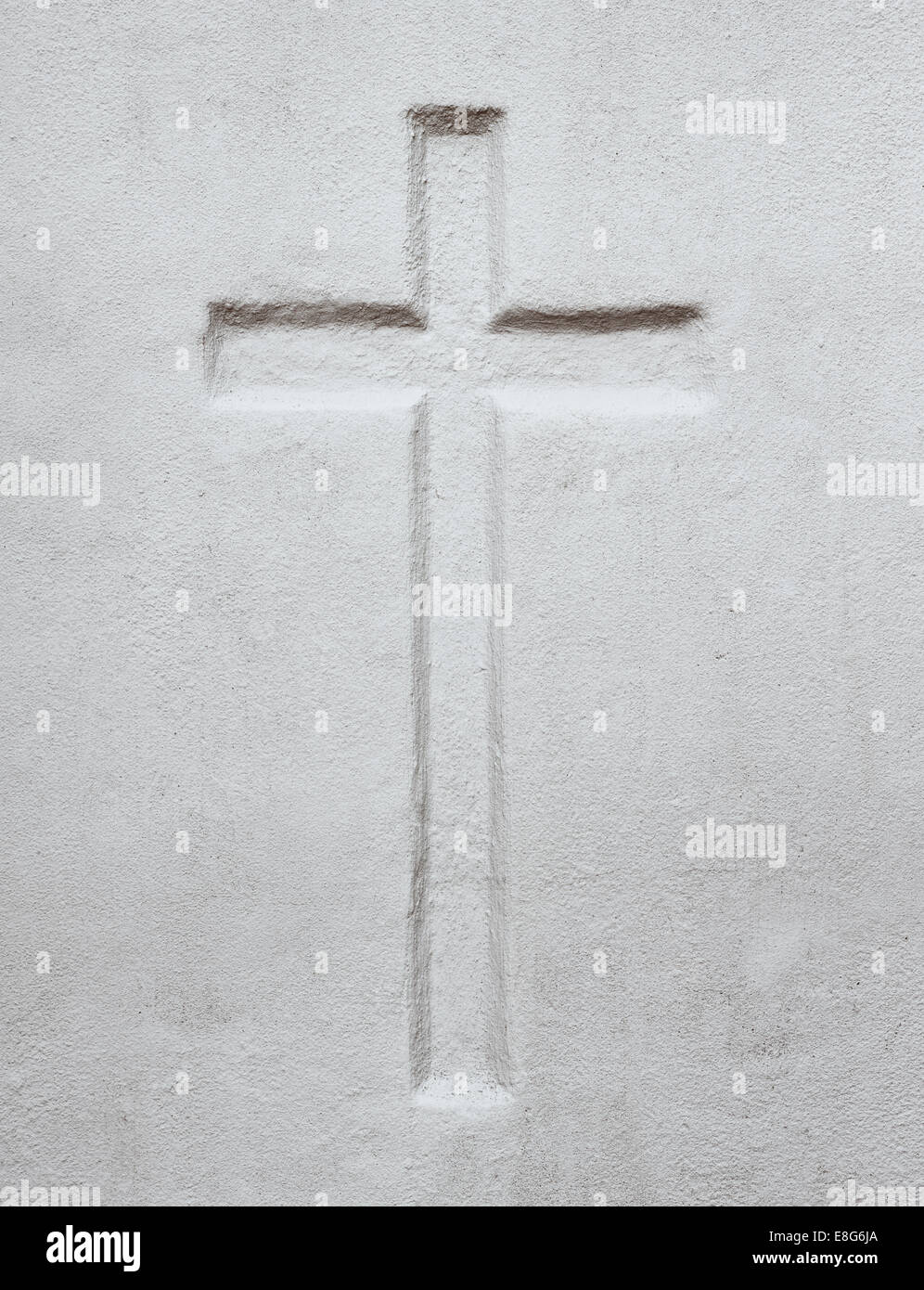 Una croce cristiana di rilievo nel muro di cemento. Foto Stock