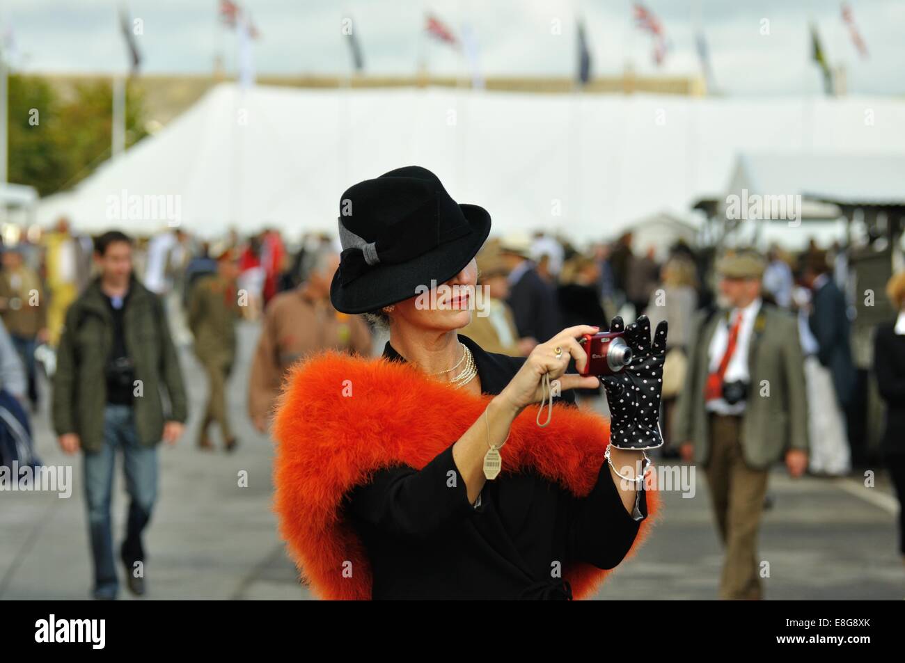 Signora indossa moda vintage di scattare una foto con un punto-e-shoot fotocamera al Goodwood Foto Stock