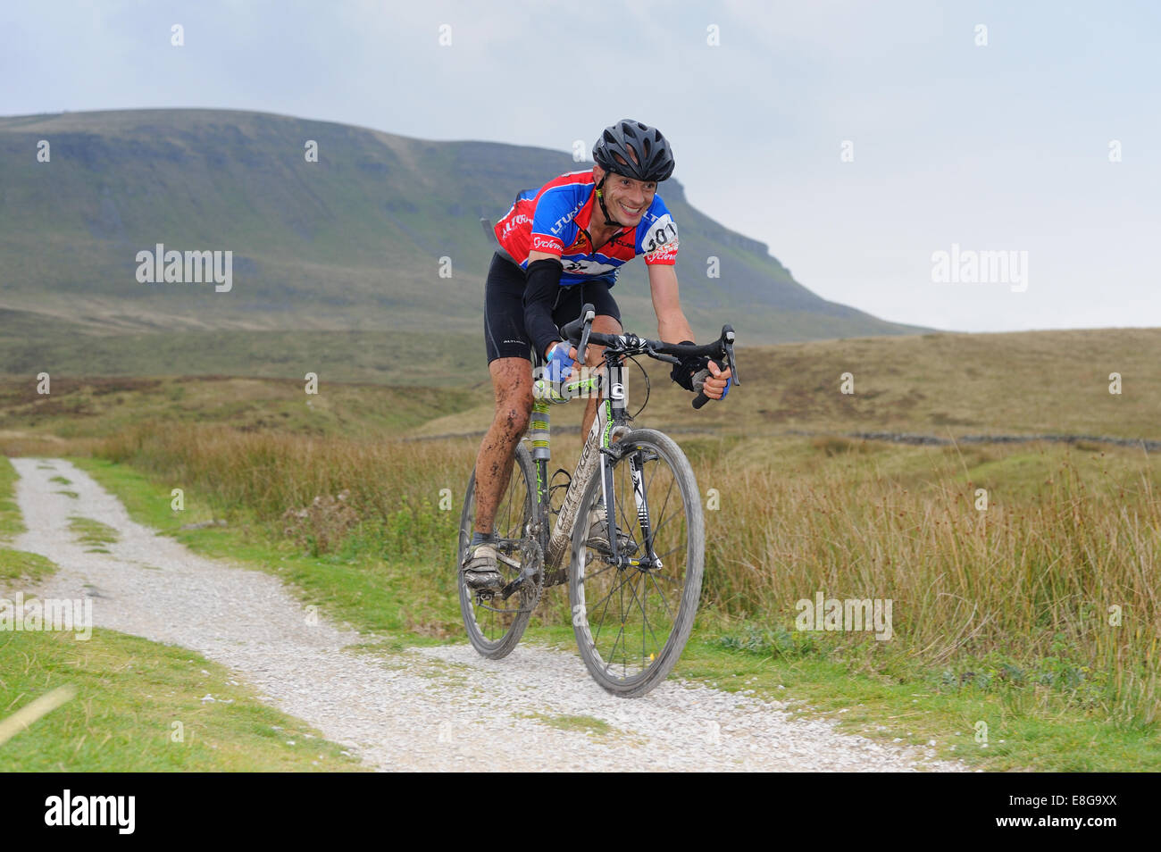 Concorrente prendendo parte a tre picchi di ciclocross gara con Pen y Gent in background Foto Stock