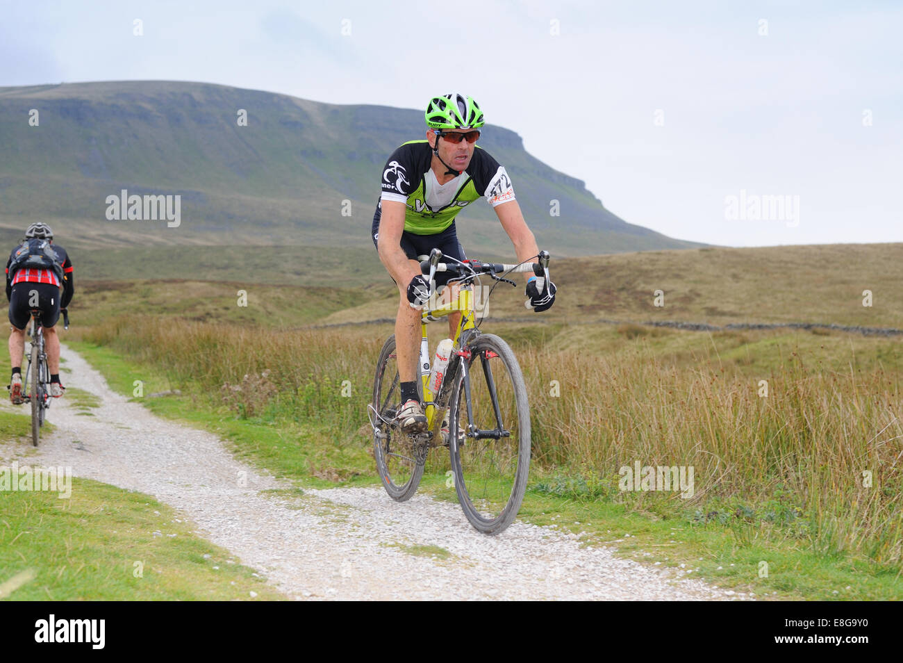 Concorrente in tre cime ciclocross gara con Pen y Gent in background Foto Stock