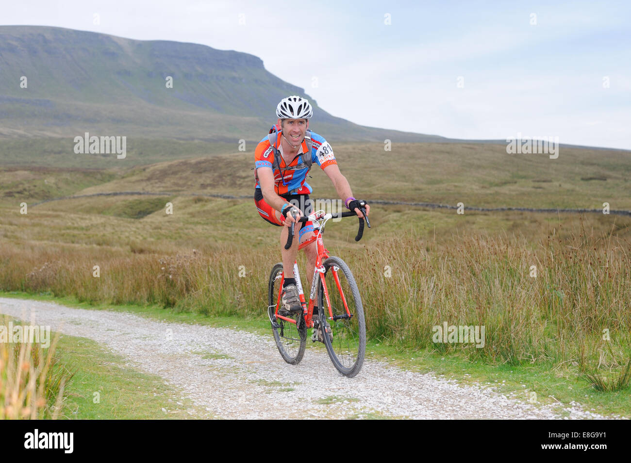 Concorrente prendendo parte a tre picchi di ciclocross gara con Pen y Gent in background Foto Stock