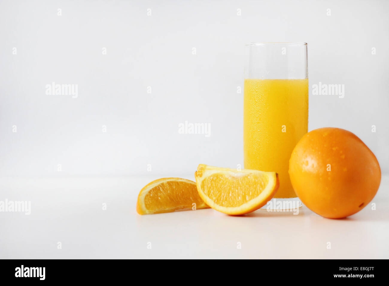 Bicchiere di succo di arancia con arance fresche Foto Stock