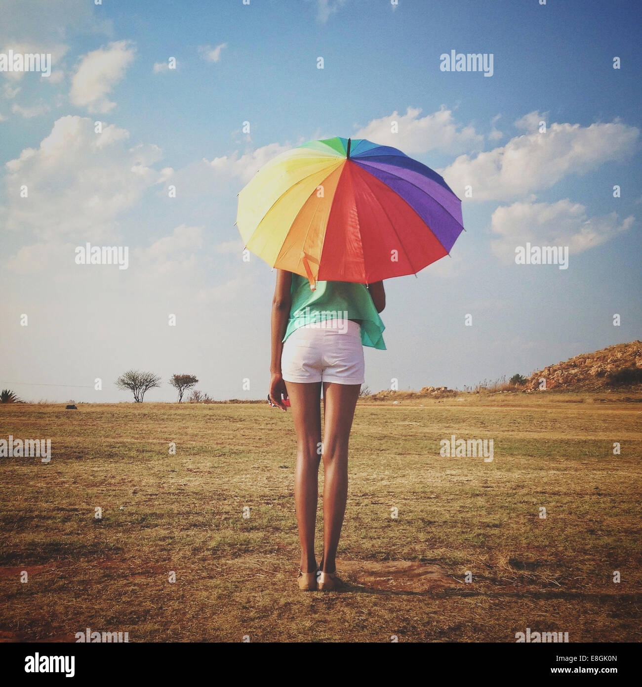 Donna che tiene un ombrello multicolore, Roodepoort, Johannesburg, Gauteng, Sudafrica Foto Stock