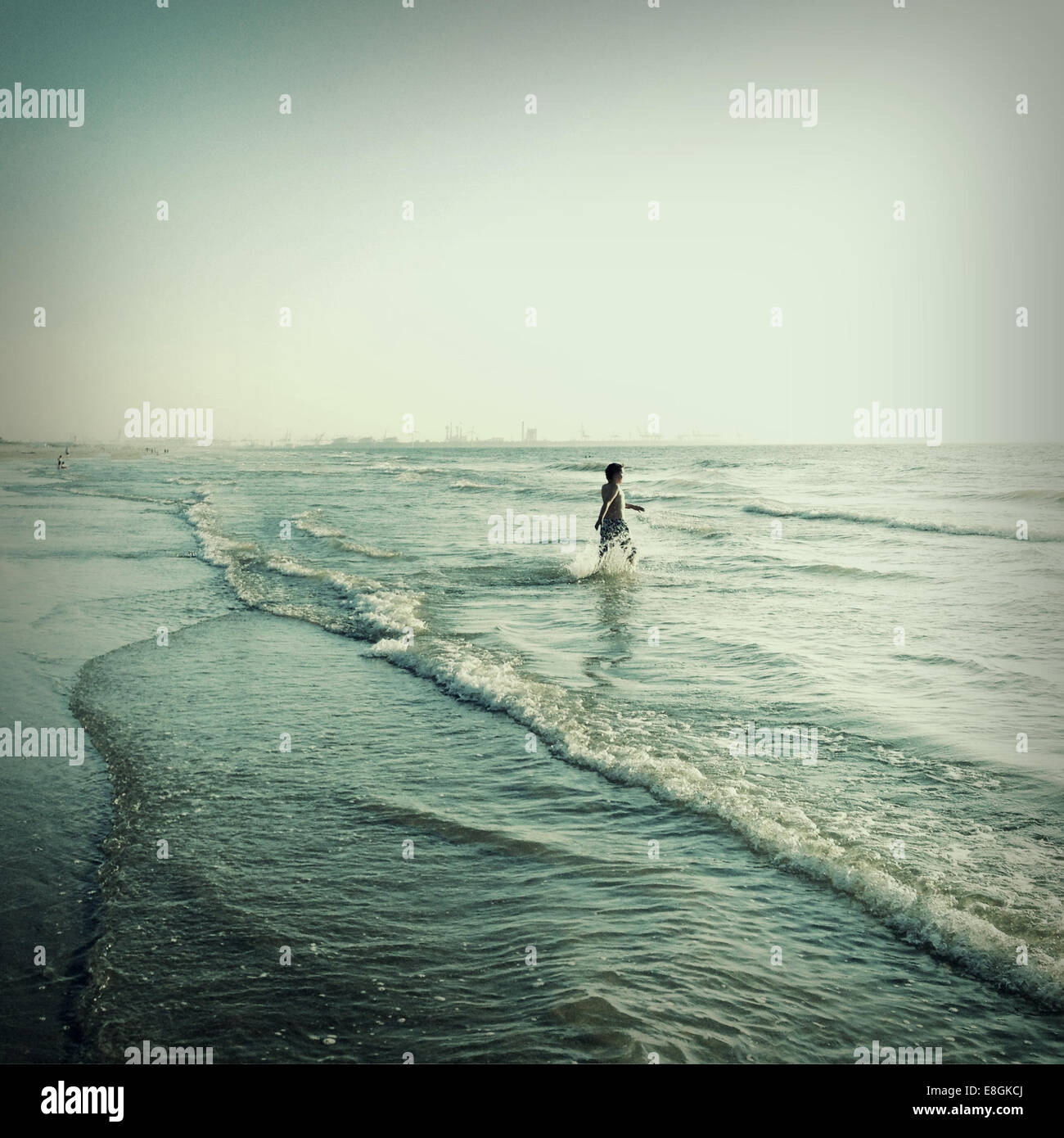 Ragazzo passeggiate in mare Foto Stock