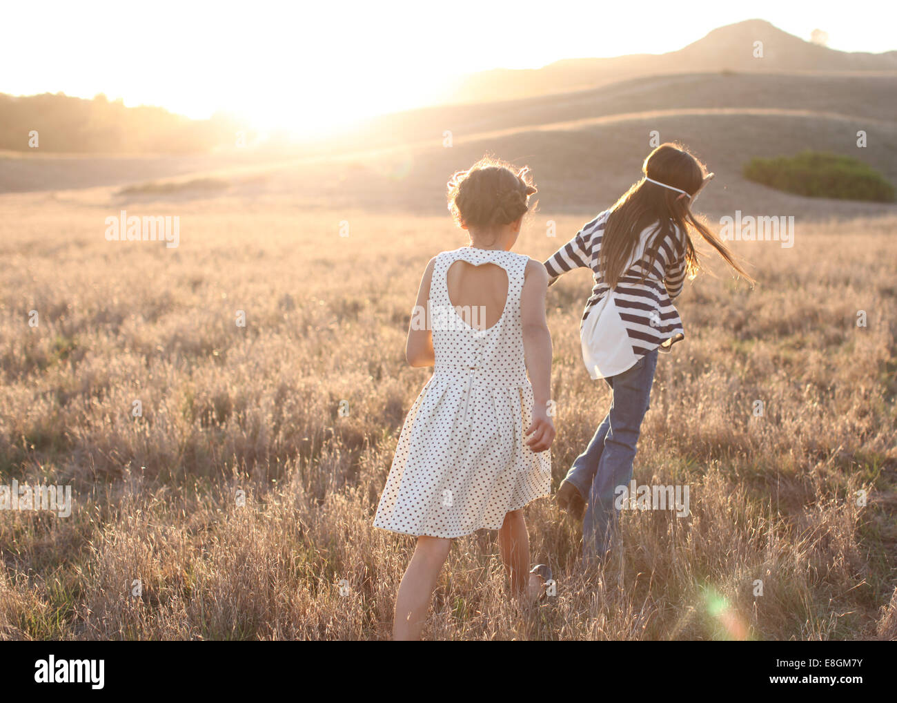 Vista posteriore di due ragazze passeggiate all'aperto Foto Stock