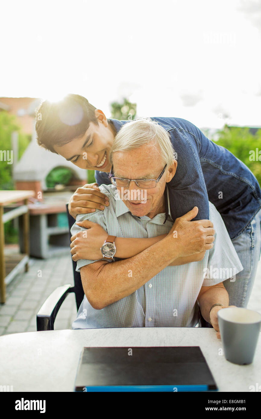 Felice giovane uomo abbracciando il nonno in cantiere Foto Stock