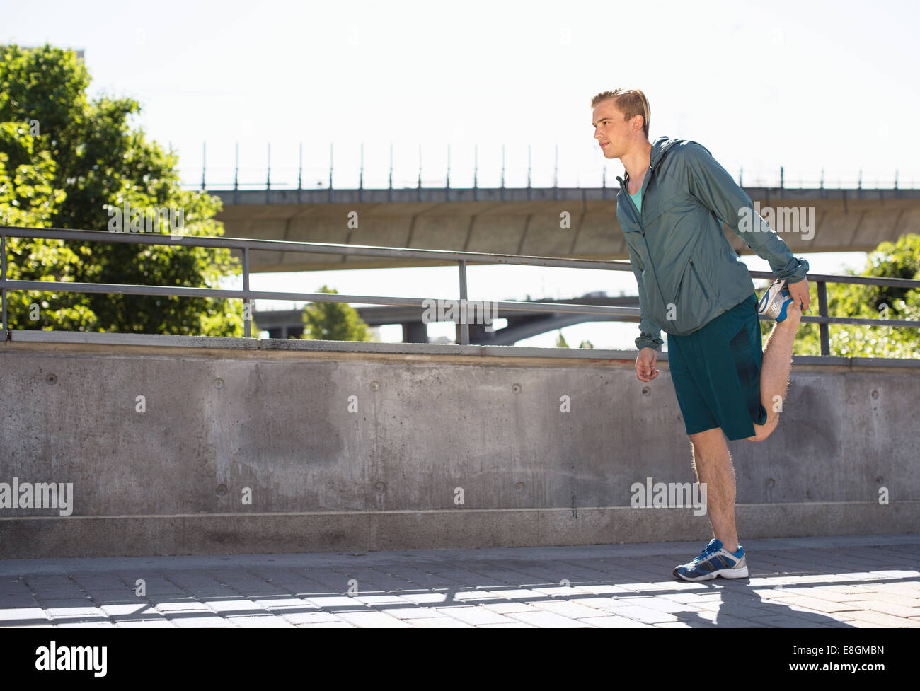 Lunghezza completa dell'uomo facendo stretching esercizio sul ponte Foto Stock