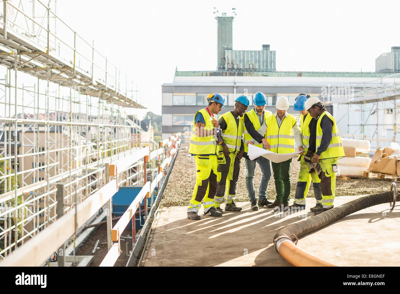 Gli architetti e i lavoratori del settore edilizio analizzando blueprint insieme al sito Foto Stock