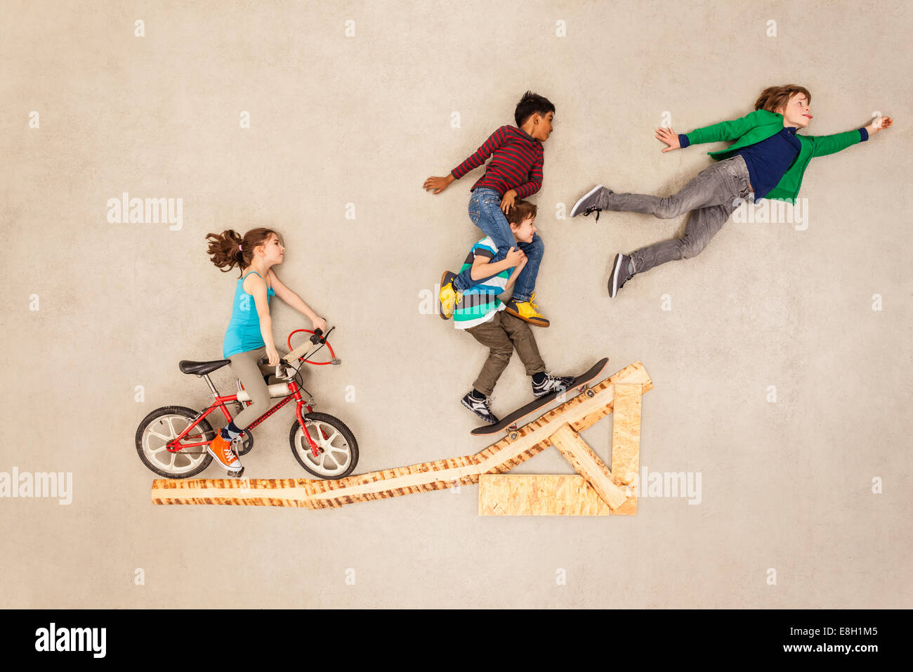 I bambini con la bici e lo skateboard su jump Foto Stock
