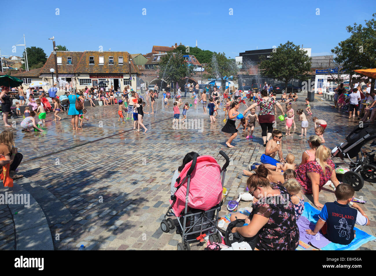 Famiglie godendo il becco di acqua fontane vicino al porto a Folkestone. Foto Stock