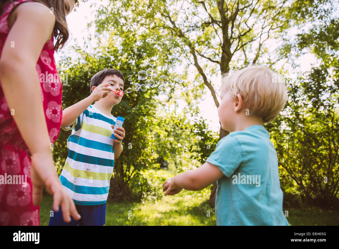 I bambini di soffiaggio bubbbles soap in giardino Foto Stock