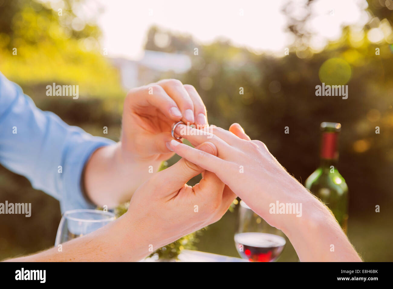 Uomo di mettere ad anello sulla donna del dito a cena Foto Stock