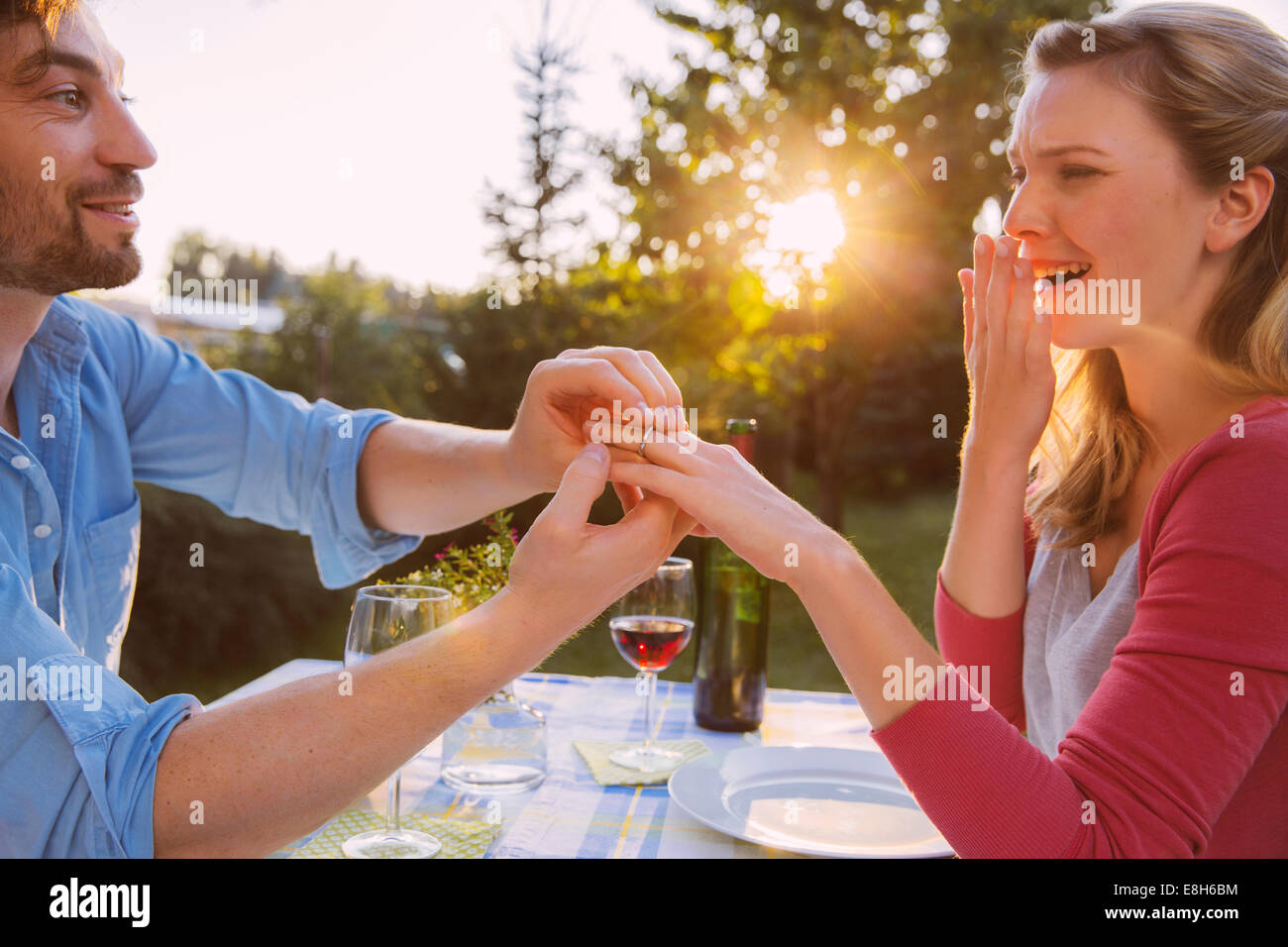 Uomo di mettere ad anello sulla donna del dito a cena Foto Stock
