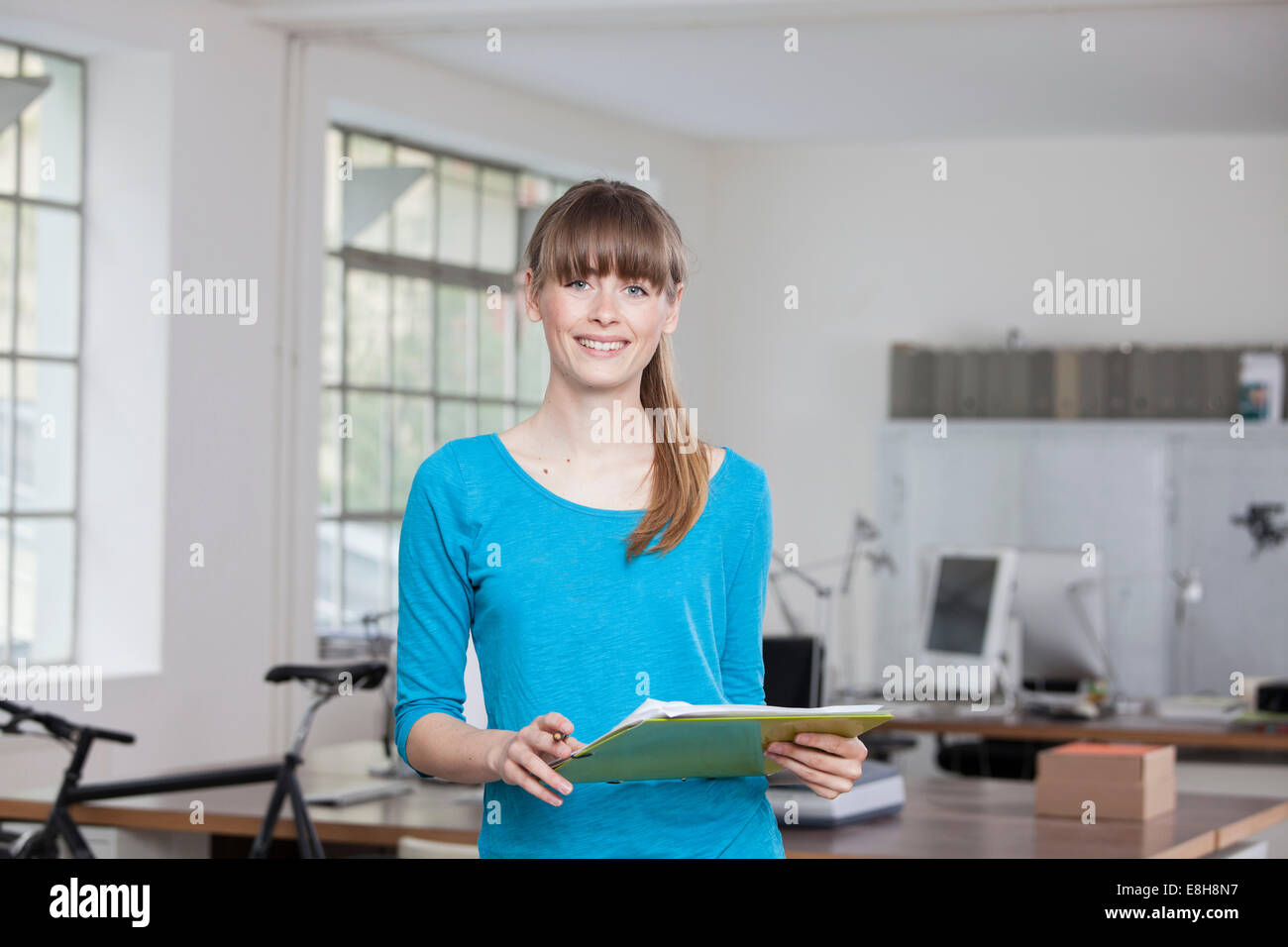 Ritratto di sorridente giovane donna in un ufficio creativo Foto Stock