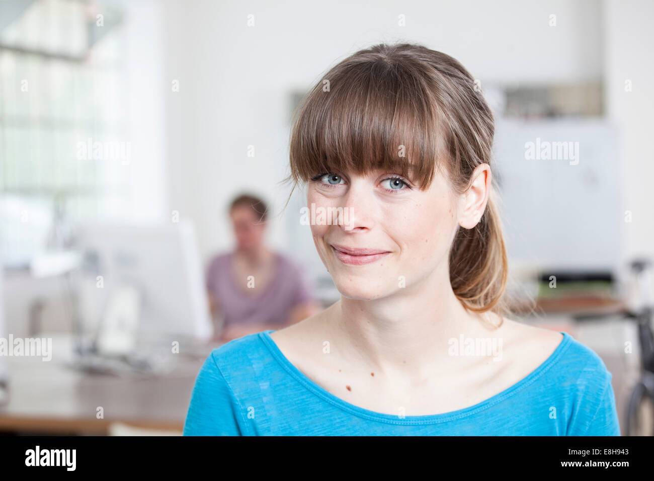 Ritratto di sorridente giovane donna in un ufficio creativo Foto Stock