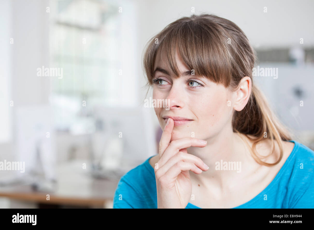 Ritratto di pensosa giovane donna in un ufficio creativo Foto Stock