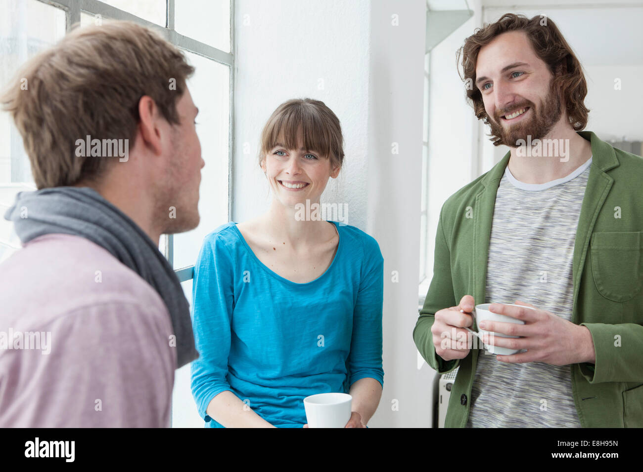Tre colleghi per comunicare in un ufficio creativo Foto Stock