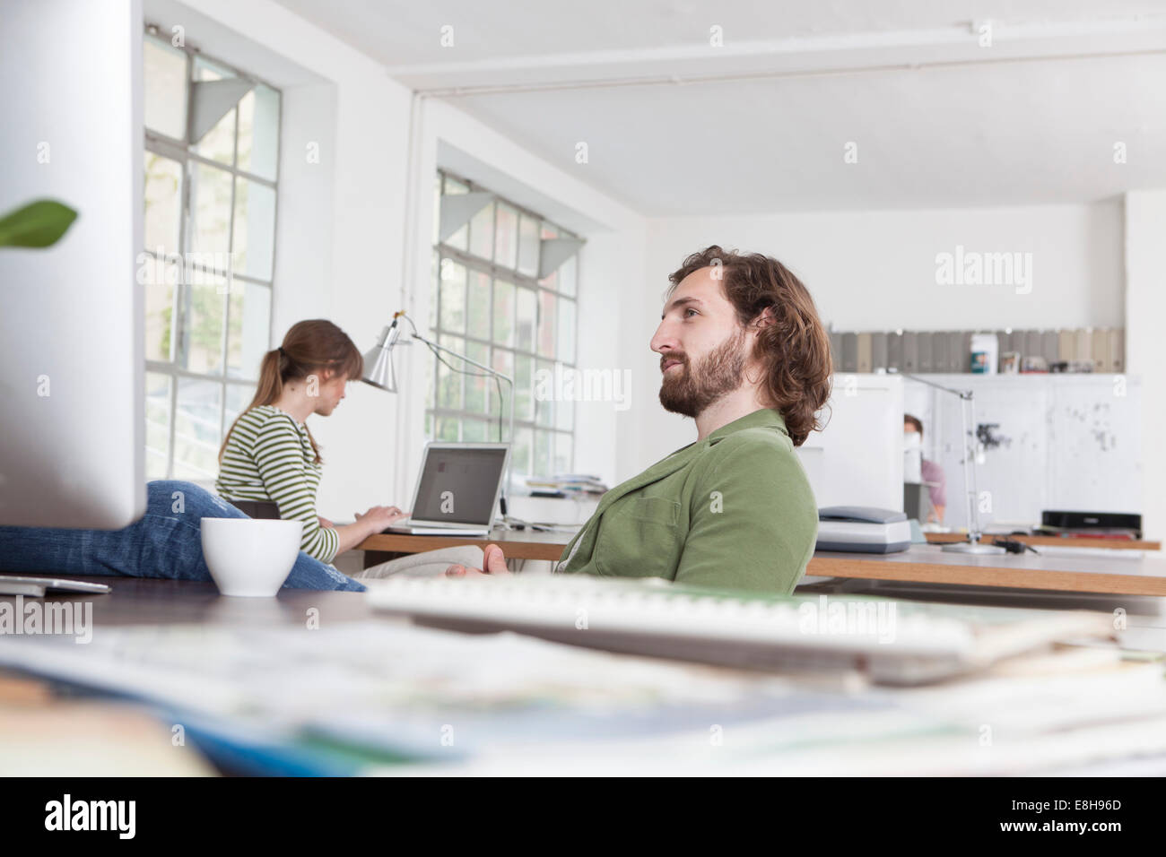 Giovane uomo di relax presso la sua scrivania in un ufficio creativo Foto Stock